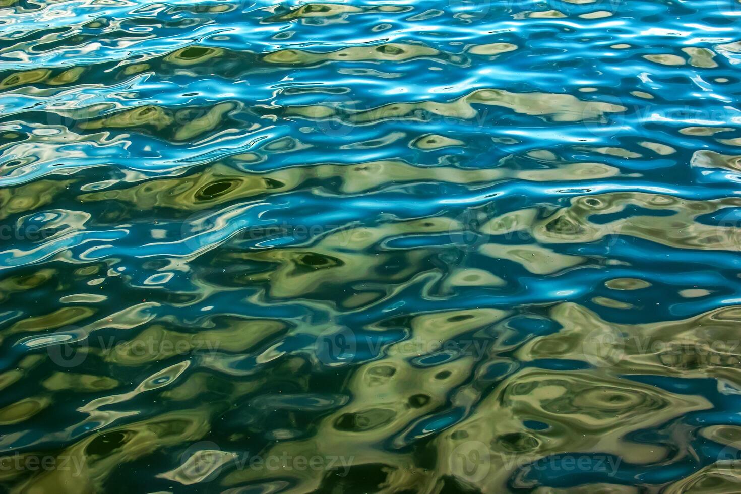 Water texture background. Wavy water surface during sunset, golden light reflecting in water. photo