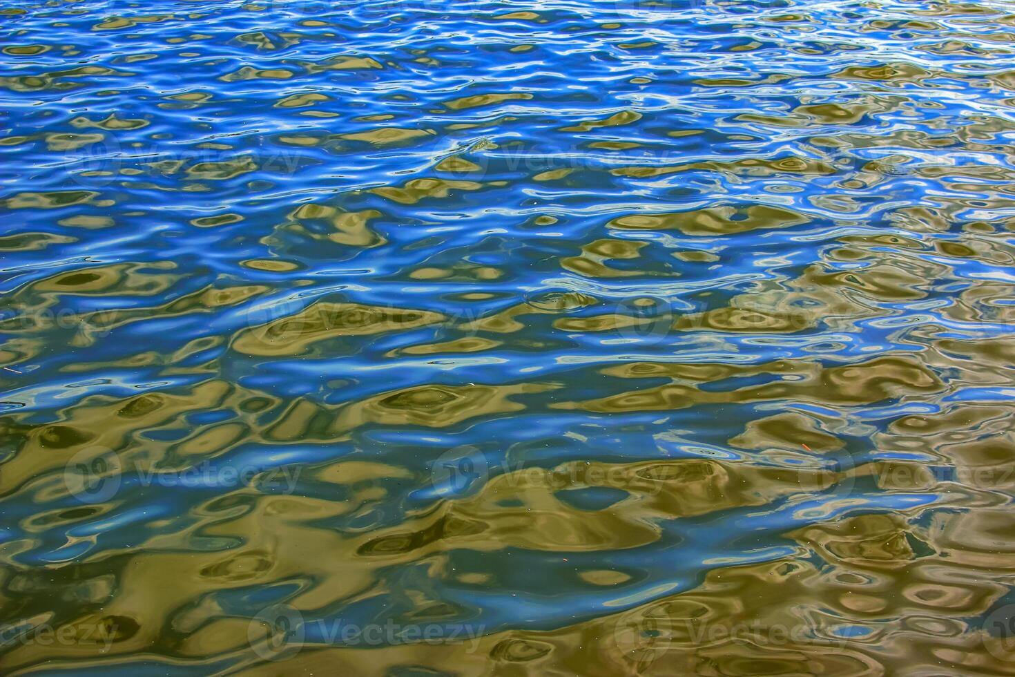 Water ripple texture background. Wavy water surface during sunset, golden light reflecting in water. photo