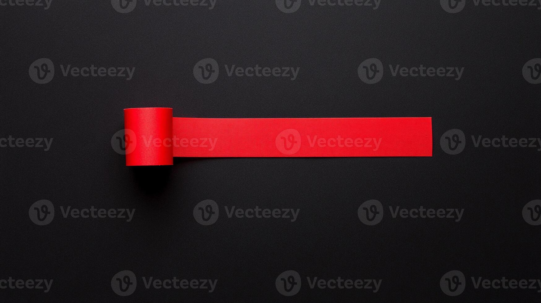 A red roll of paper on a black surface photo