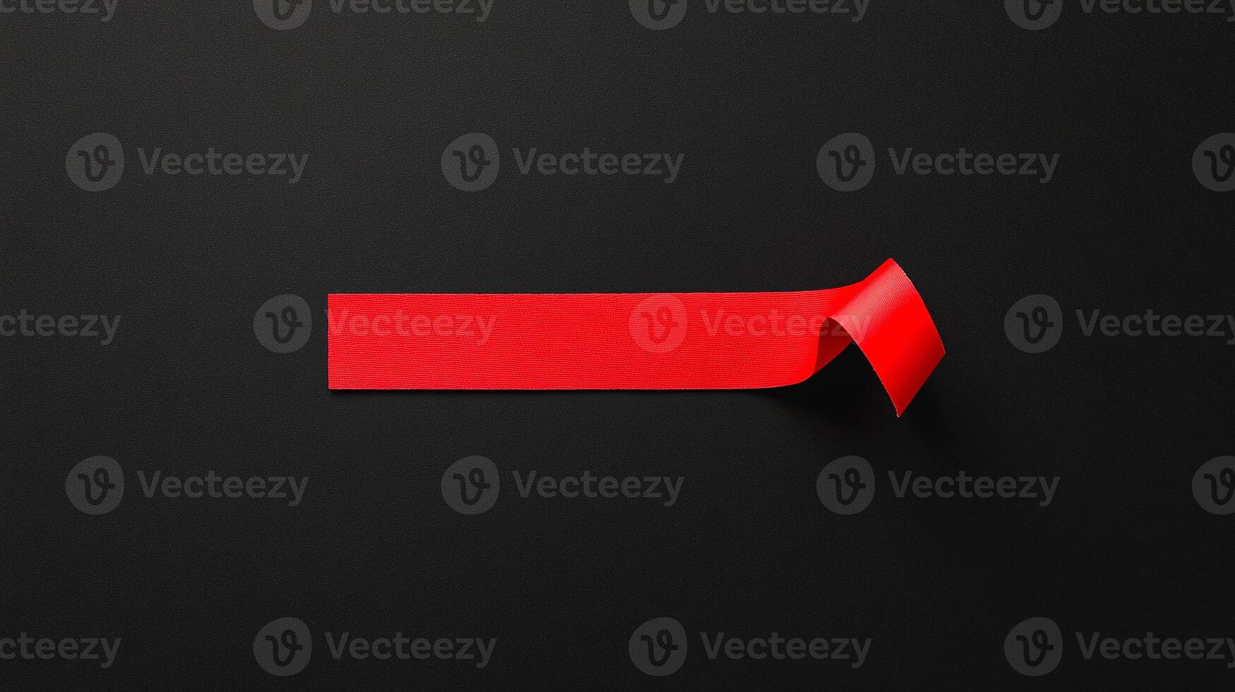 A red piece of paper is placed on a black background photo