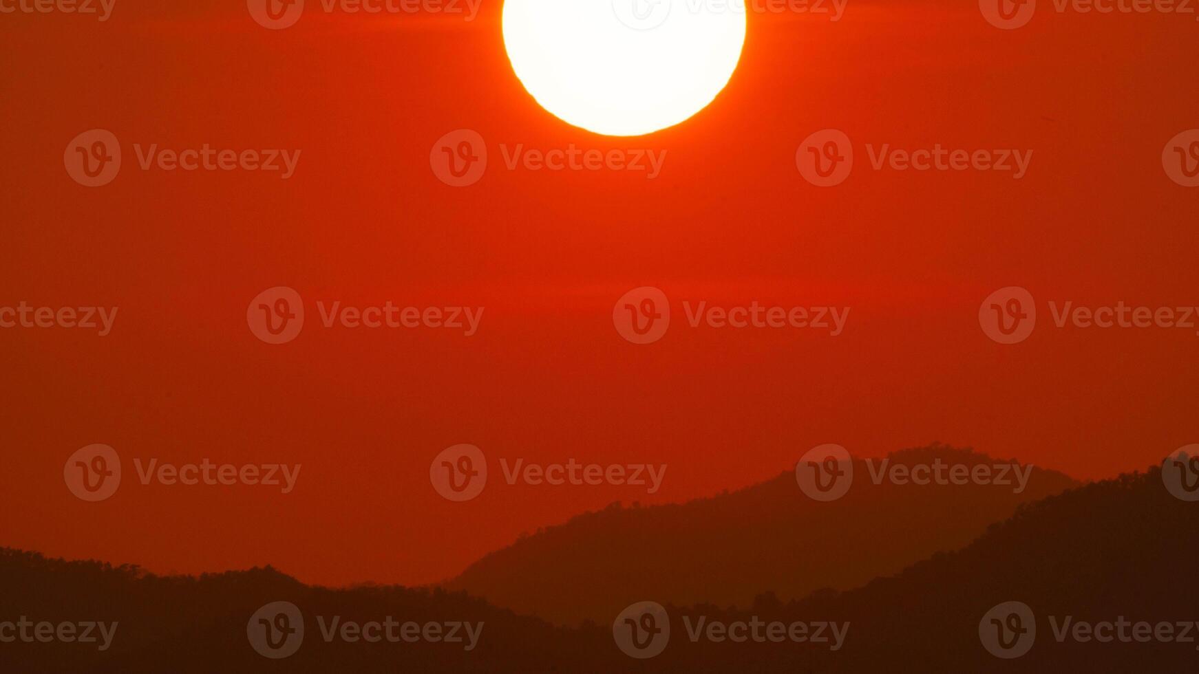 Timelapse shot of a beautiful sunrise over the horizon with an orange winter sky. Close-up of the sunrise. photo