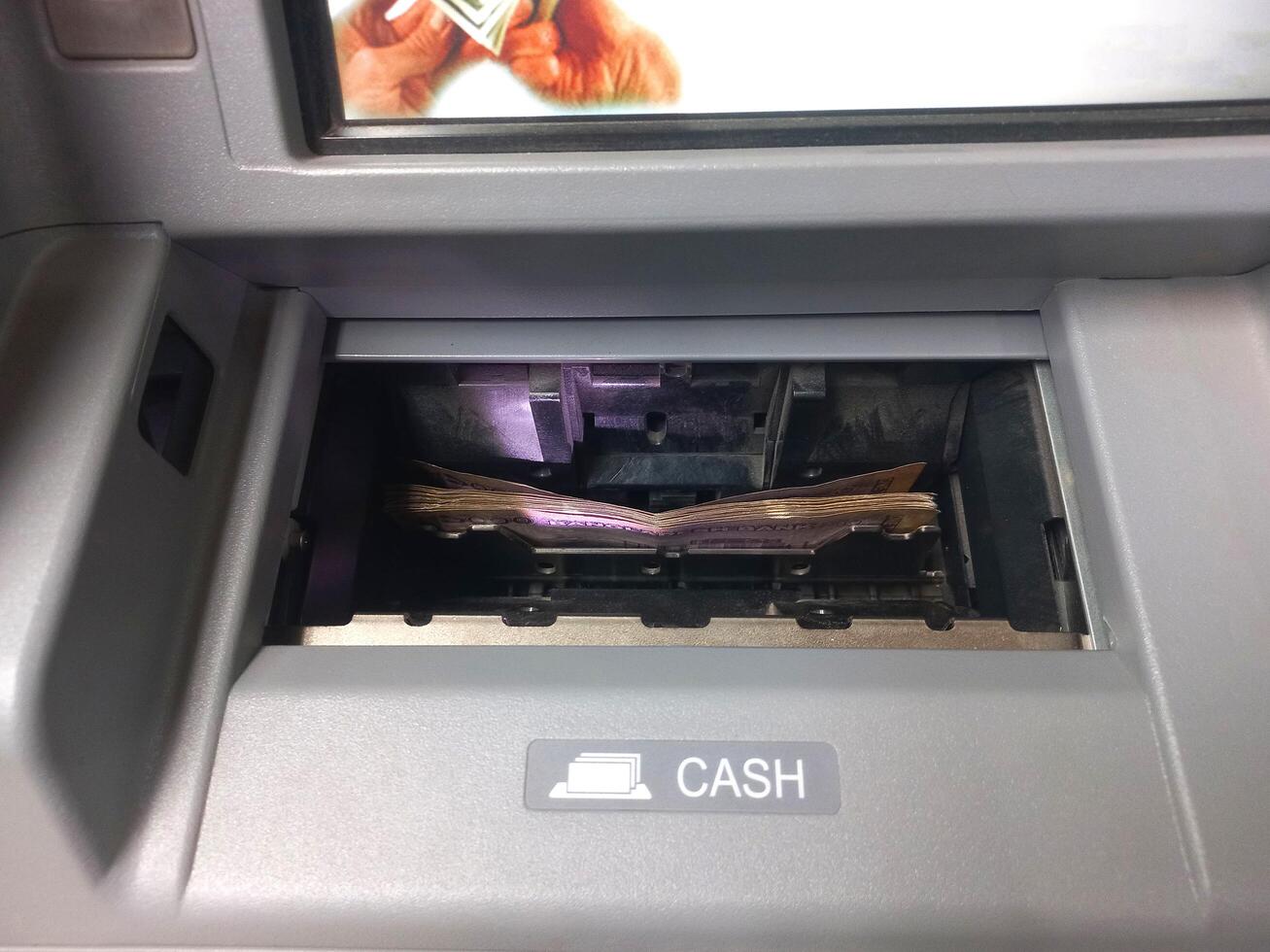 Withdrawing funds from the ATM. Cashing out money from the bank. photo
