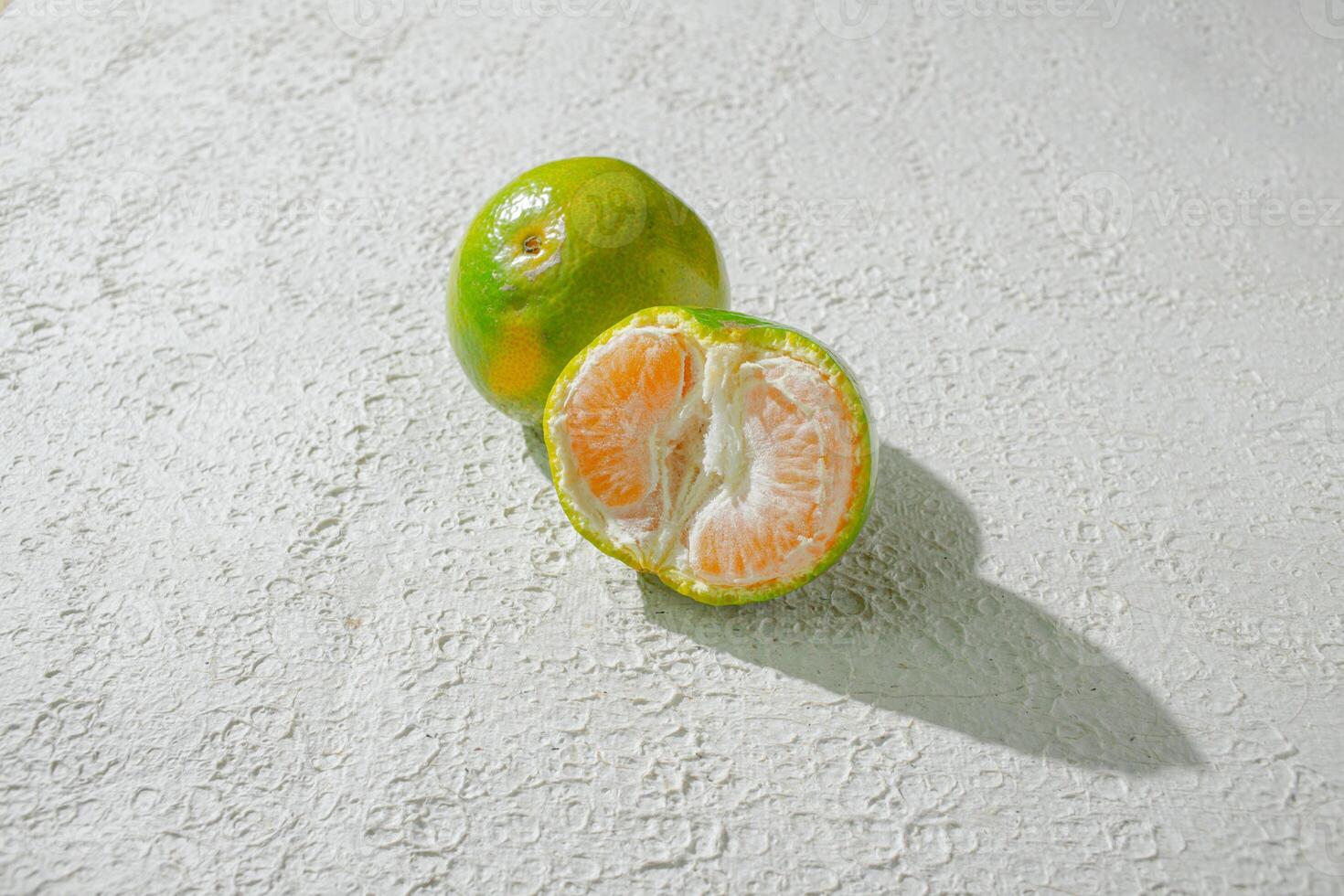 a half of an orange on a white surface photo