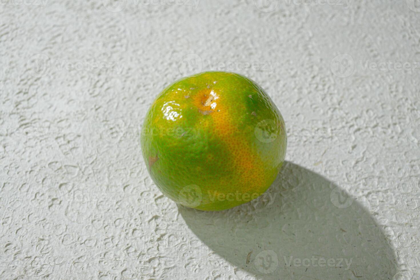 a lime orange on a white surface photo