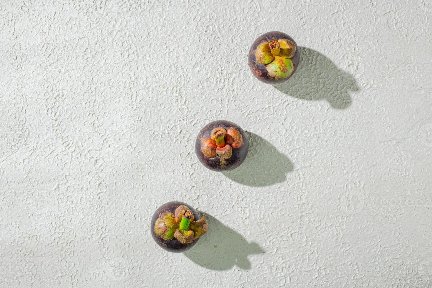 Mangosteen fruit displayed against a textured white background, emphasizing its unique purple rind and freshness. perfect for digital asset and deisng fruit photo