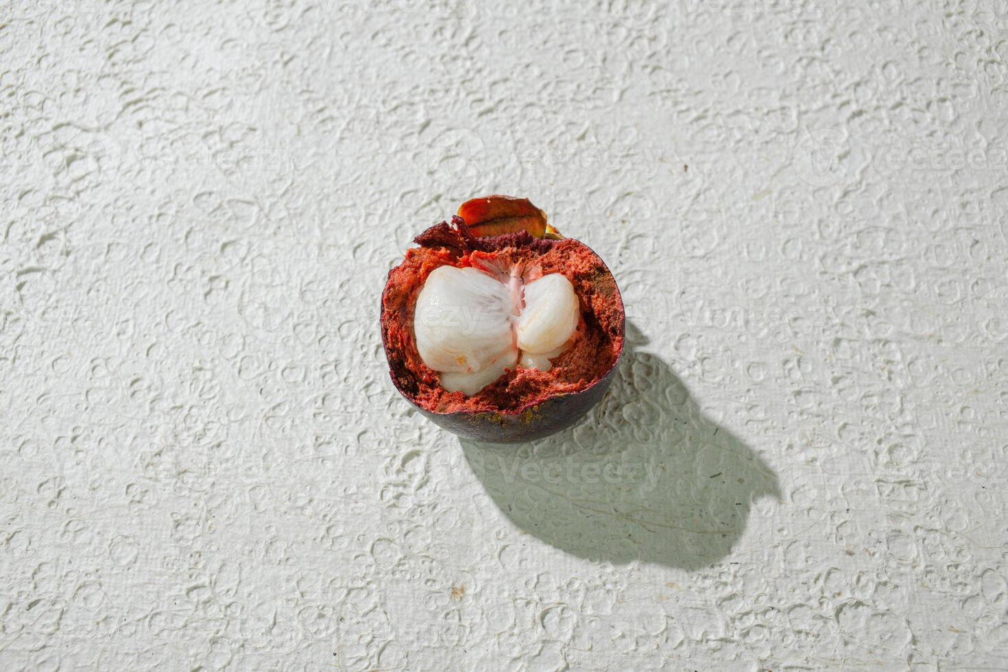 a mangosteen fruit with a shell on it. isolated on white texture background photo