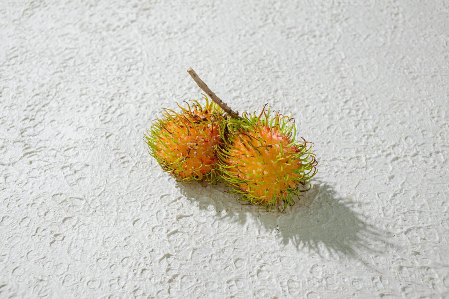 Fresh yellow rambutan on a textured white background, perfect as a digital asset for design projects, posters, advertisements, or creative media photo