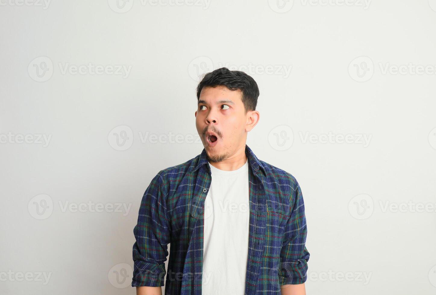 Portrait Of Surprised Asian Guy Opened Mouth In Amazement, Shocked Young Man Looking Stunned And Impressed, Emotionally Reacting To News photo