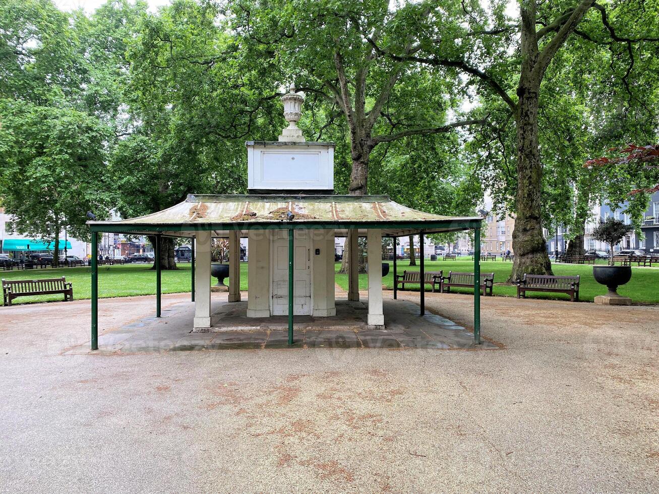 A gazebo in a park with trees and benches photo