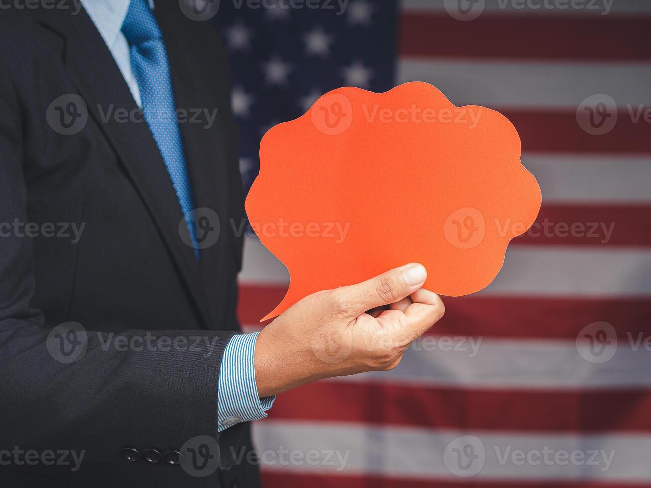 Hand businessman holding a blank red speech bubble while standing on the American flag background photo