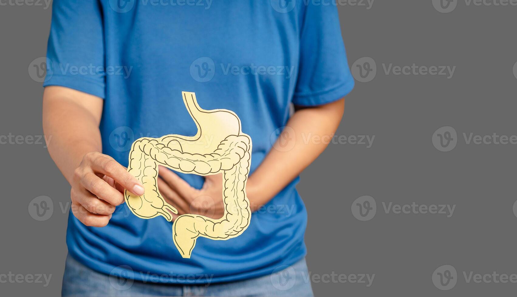 Close-up of hands holding a colon symbol and touching stomach painful suffering from stomachache photo