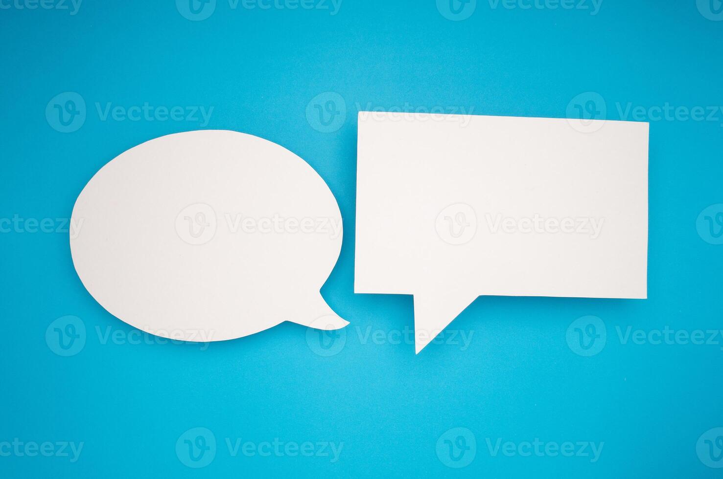 A blank white speech bubbles on a light blue background photo
