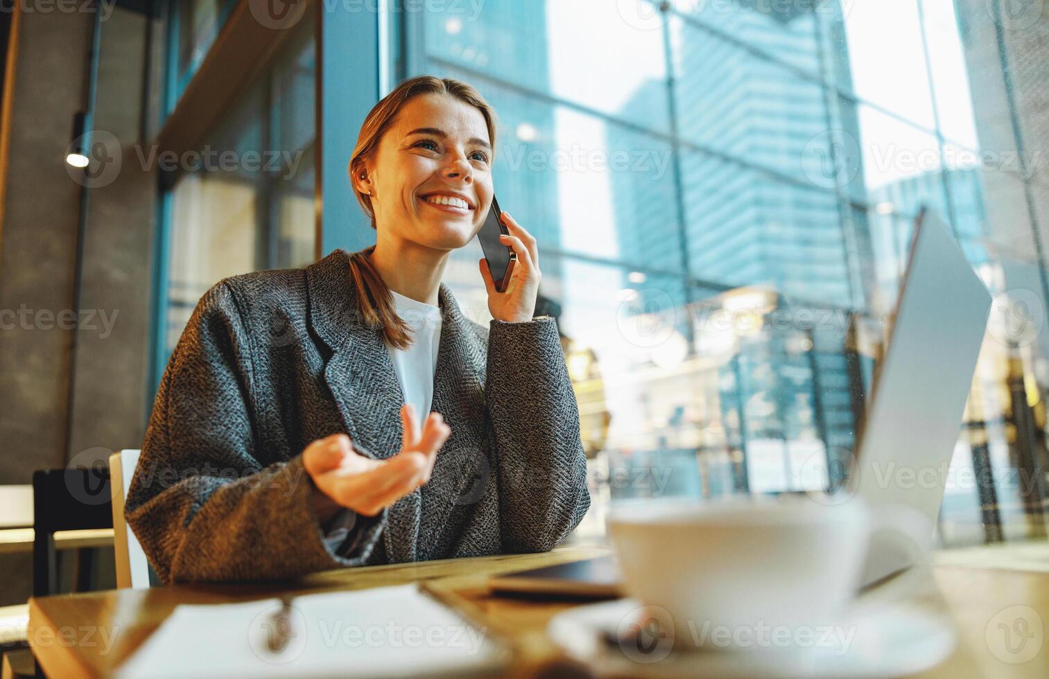 Smiling woman manager talking with client and work on laptop in coworking. Distance work concept photo