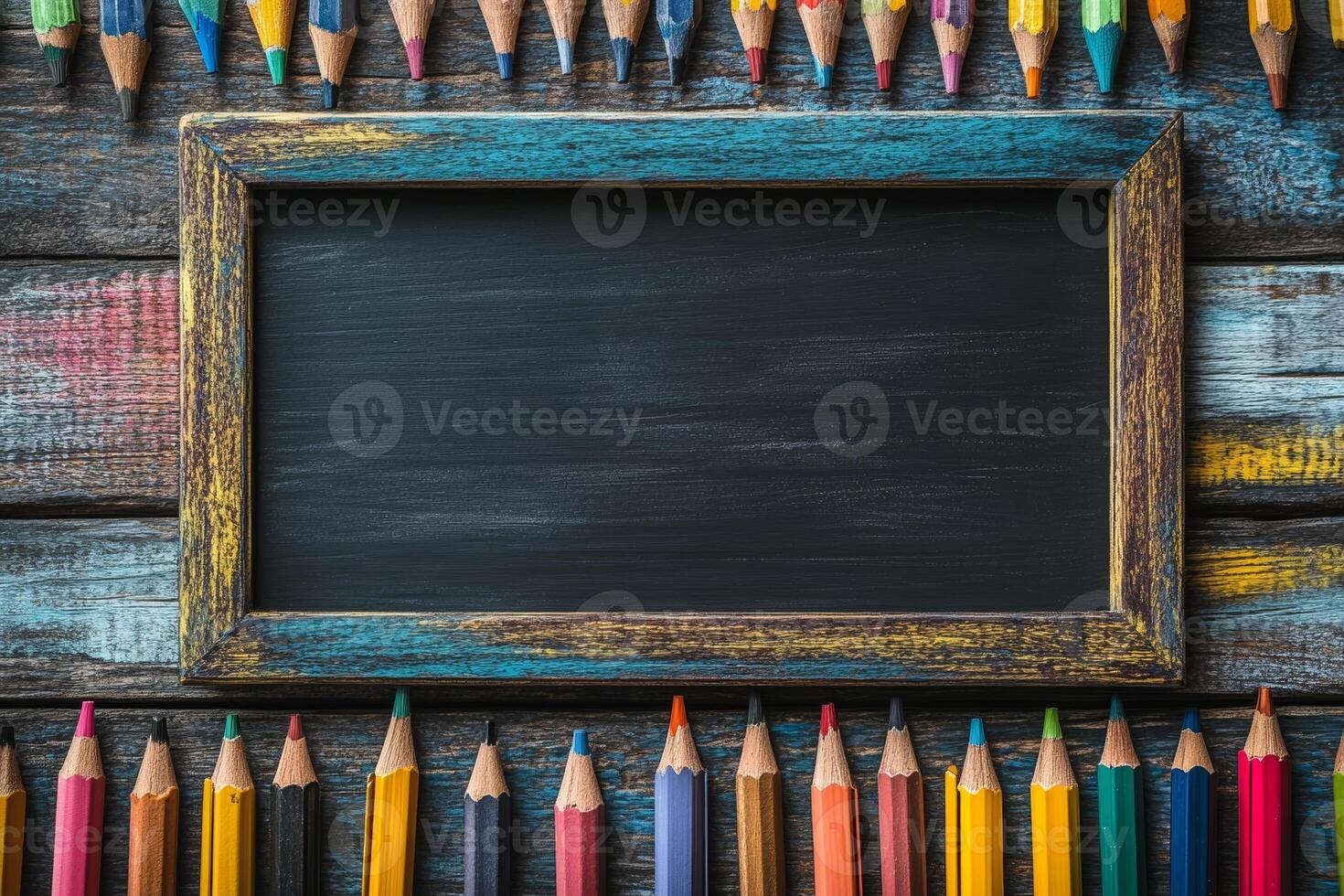 A rustic frame surrounded by colorful pencils on a wooden surface, ideal for creative projects. photo