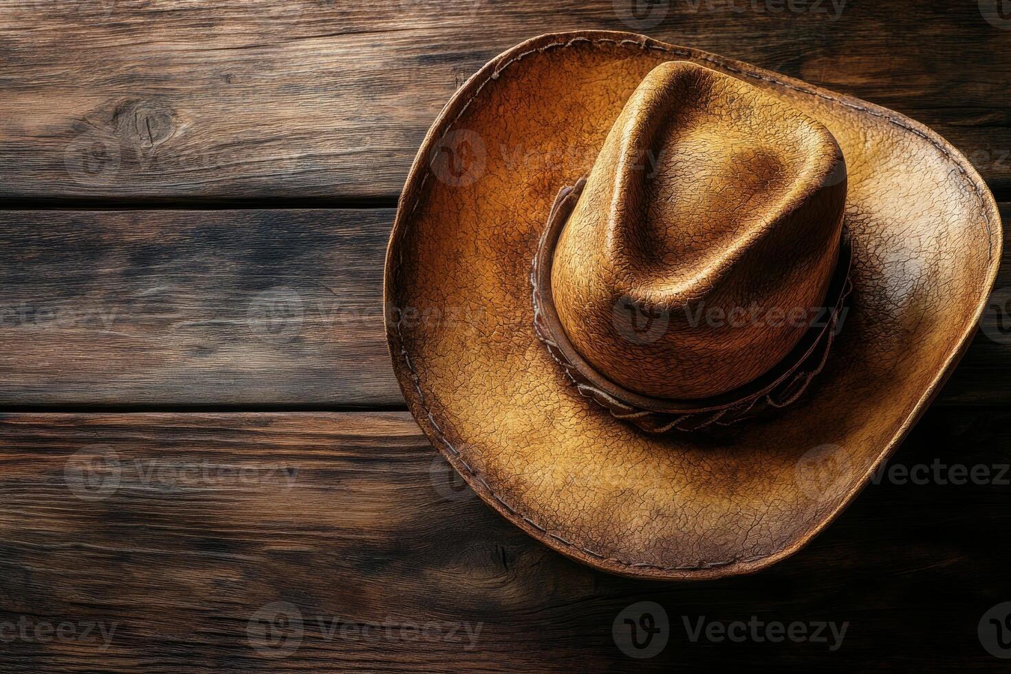 A rustic cowboy hat resting on a wooden surface, showcasing its texture and craftsmanship. photo