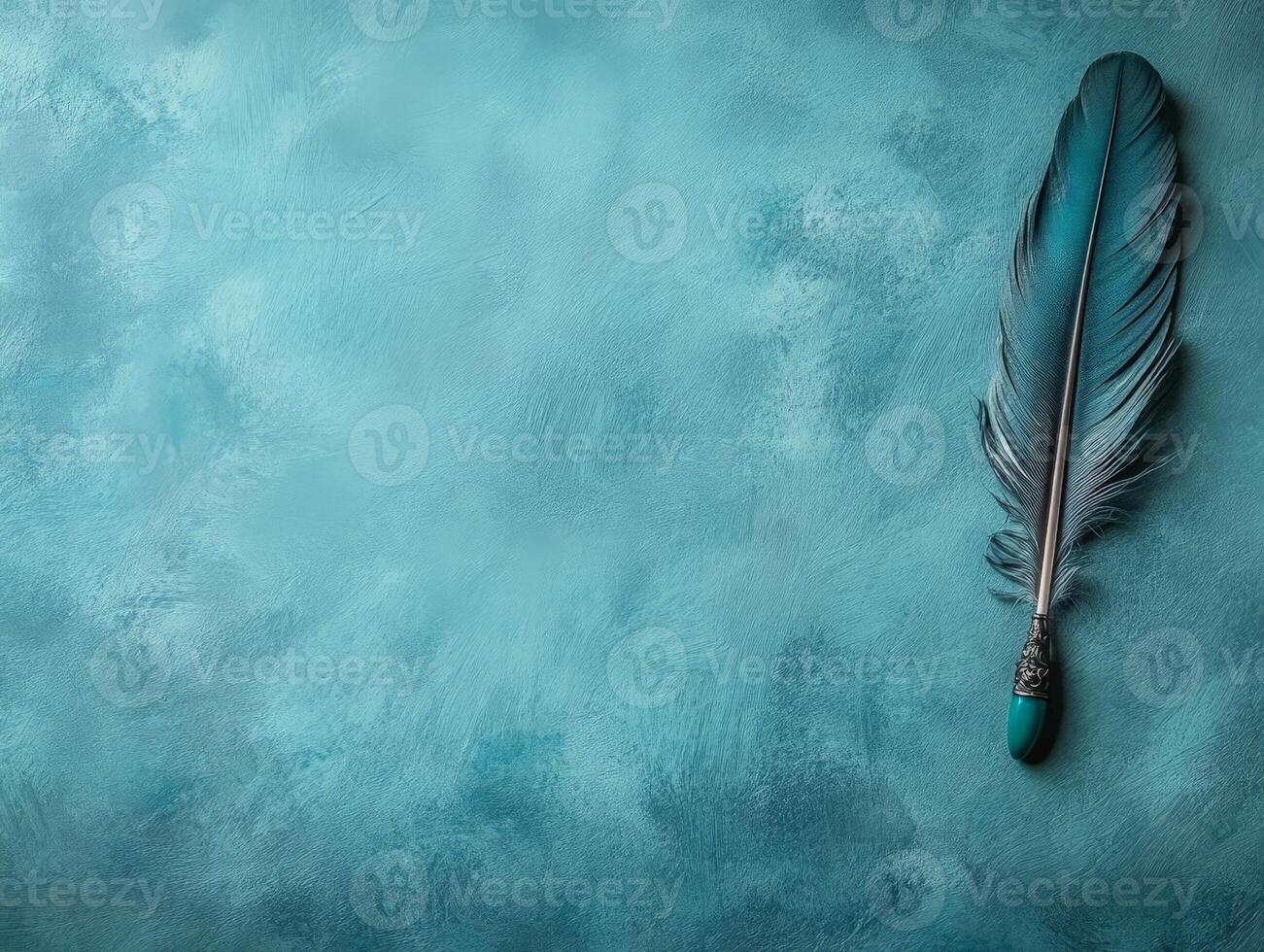 A decorative feather quill rests on a textured turquoise background, evoking creativity. photo
