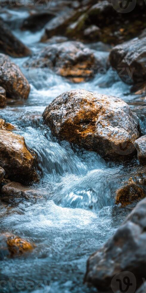 Flowing water cascades over smooth stones in a tranquil natural setting for mobile phone wallpaper photo