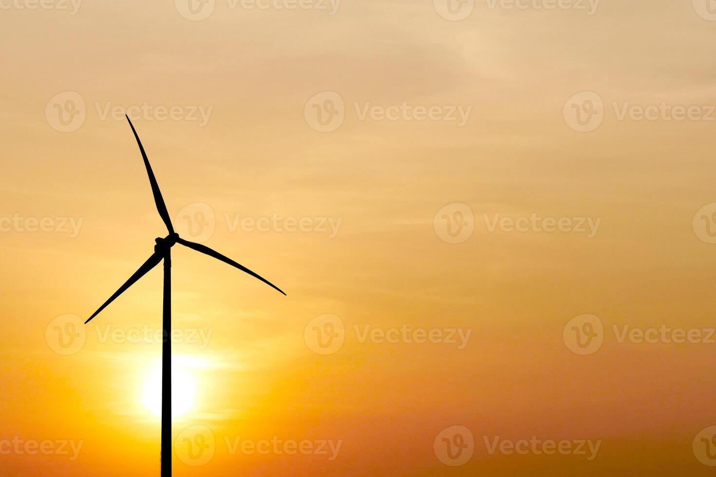 Wind Turbine Silhouette Against Golden Sunset Sky Capturing Renewable Energy and Sustainable Power Generation photo