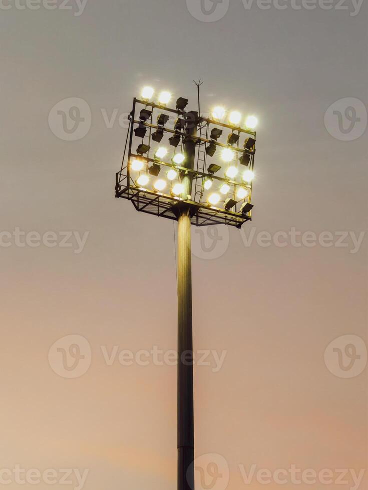 Illuminated Stadium Floodlight Against a Soft Evening Sky Capturing the Essence of Sports and Outdoor Events photo