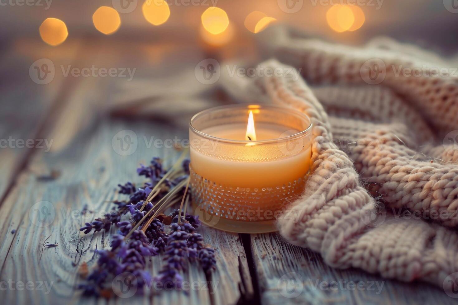 Close-Up of Lit Candle on Rustic Wooden Table with Lavender and Knitted Fabric photo