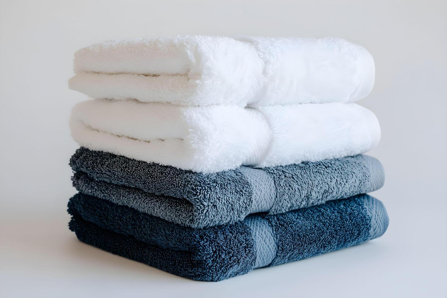 A stack of four towels on a white surface photo