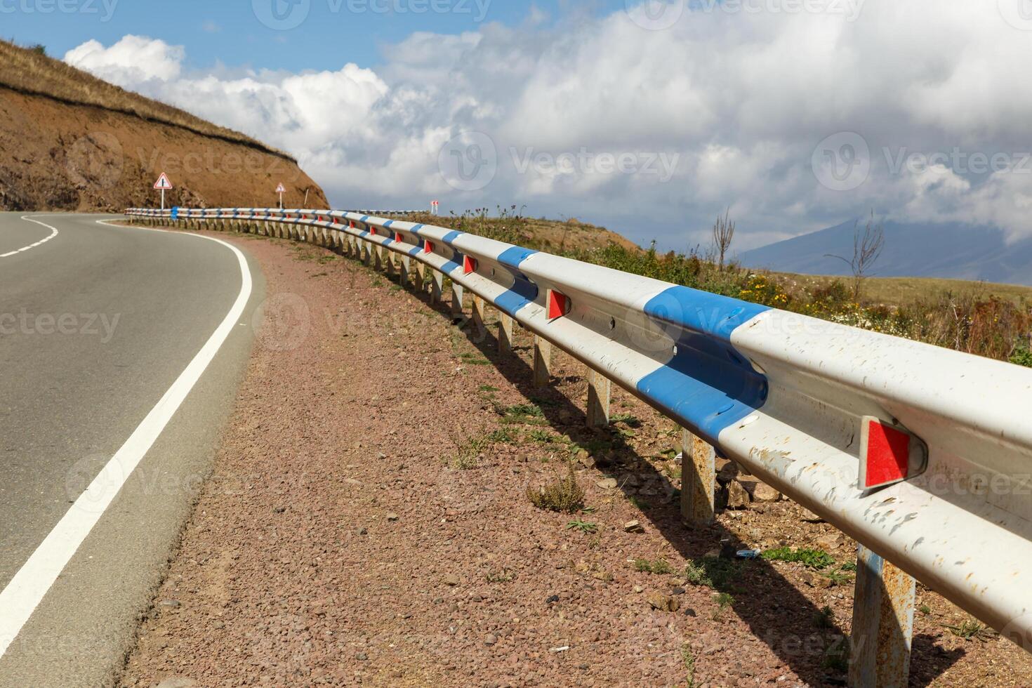 Scenic highway with guardrail winding through the mountains of Armenia on a clear day photo