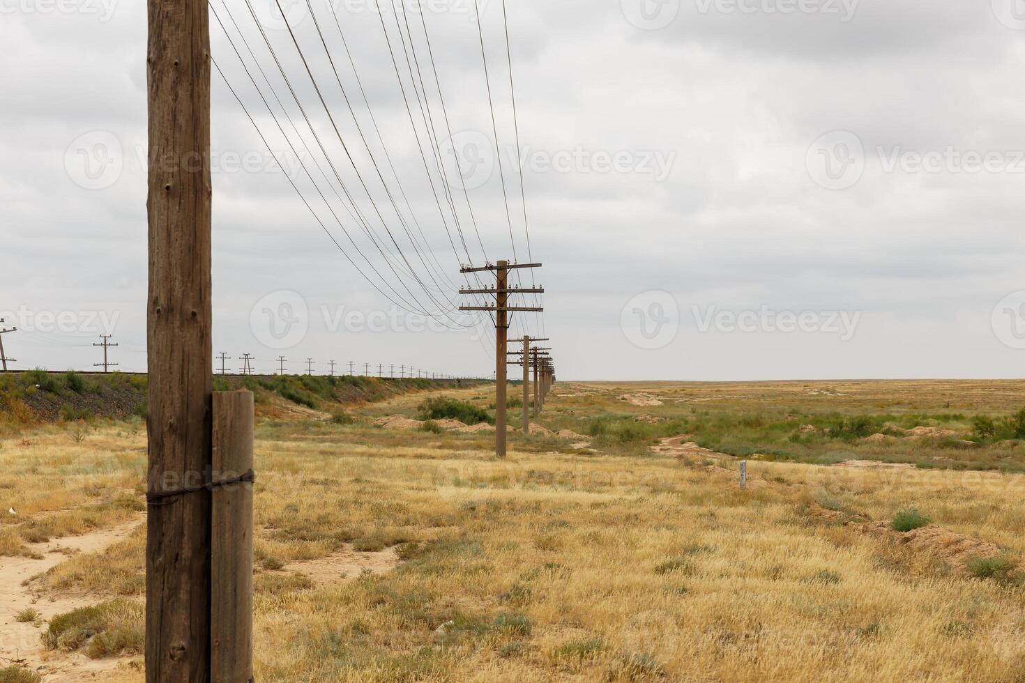 Communication line alongside the railway in the vast landscape of Kazakhstan photo