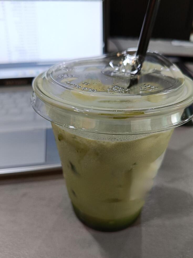 Closeup of a cup of matcha latte on the desk photo