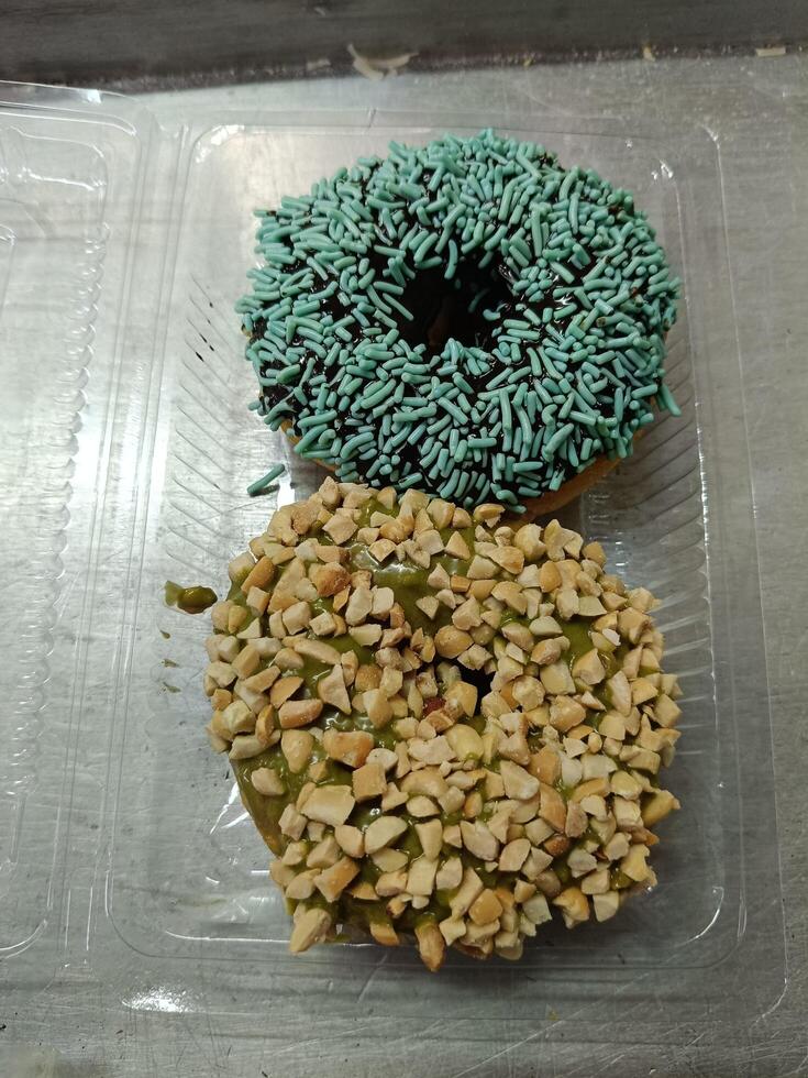 Sweet matcha jam and crushed peanuts and chocholate jam combined with mint sprinkles as a donut topping. photo