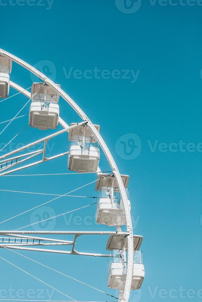 Fragment of abstract white ferris wheel against clear blue sky photo