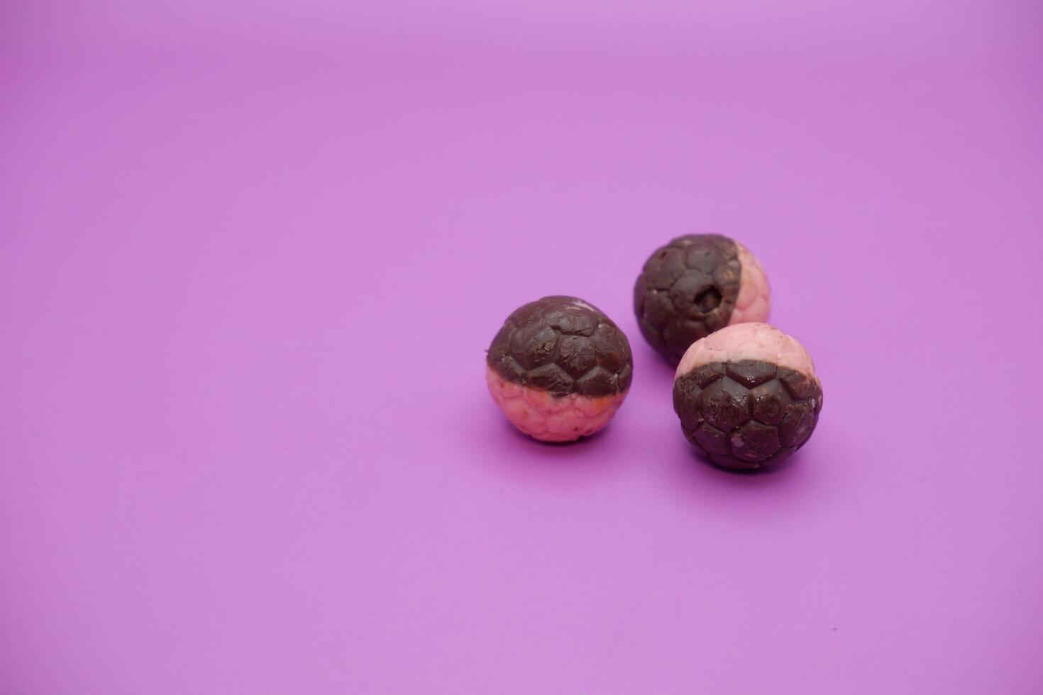 Soccer Ball Shaped Chocolate Snack with Half Pink and Half Brown Coating on Purple photo