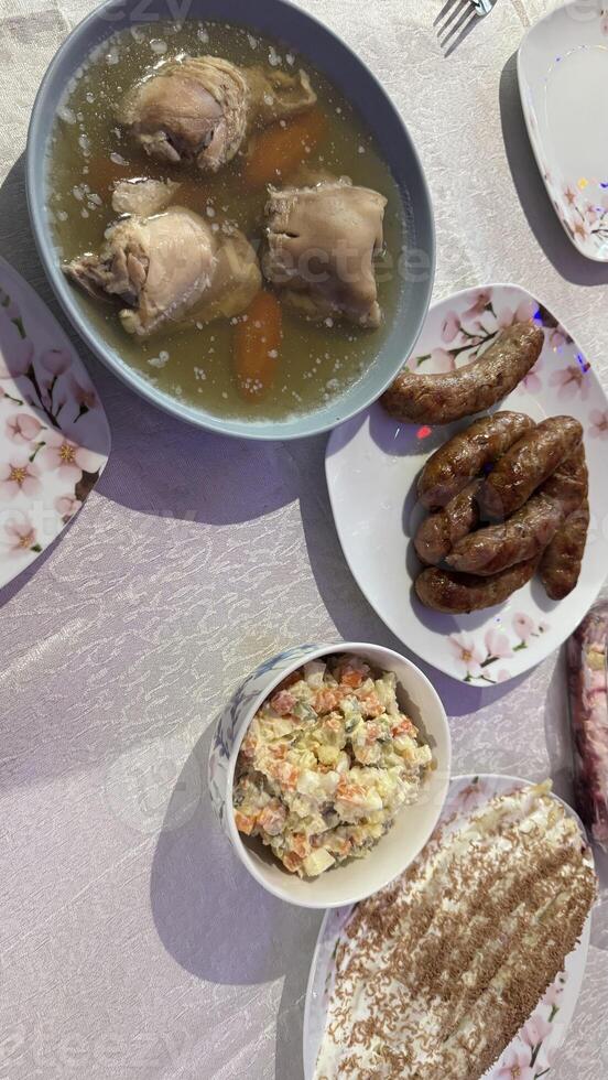 Jellied Meat, Sausages, Salad, and Cake on Table photo