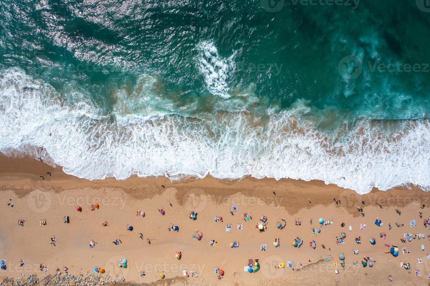 Overhead drone shot of anonymous tourists and parasols on seashore photo
