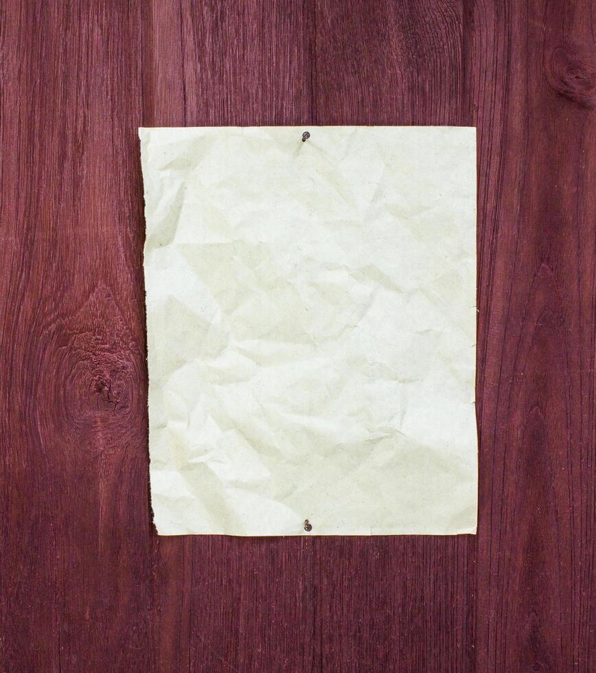 Crumpled paper document on wooden surface still life photography natural lighting close-up view photo