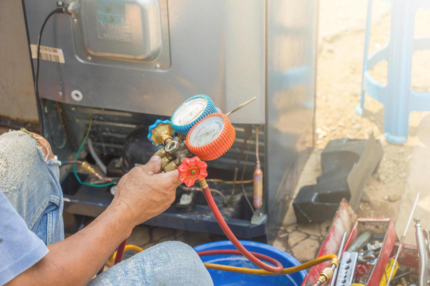 repair refrigerator job with pressure gauge , technician vacuum system refrigerator at maintenance shop. photo
