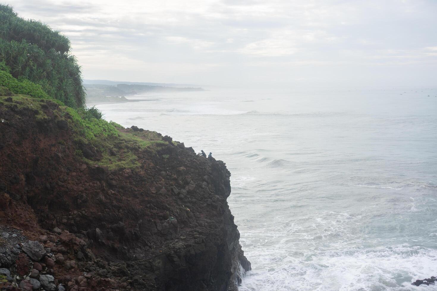 view of the cliffs on the beach with sea and clear sky photo
