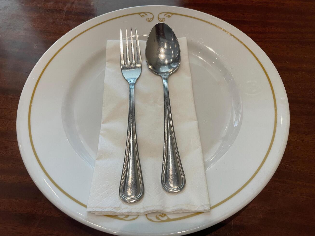 Elegant Table Setting, White Plate with Gold Rim, Silverware, and Napkin photo