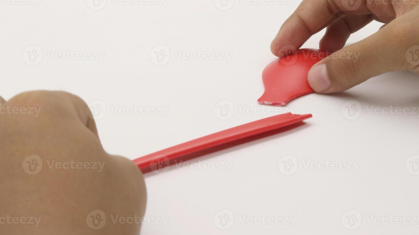 a child's hands are holding two red plastic spoons-9 photo
