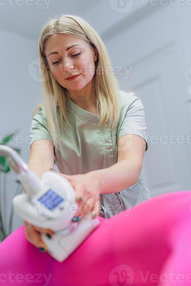 The masseur is preparing to make an hardware anti-cellulite massage in a beauty salon. photo