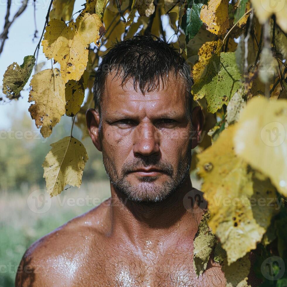 Shirtless man with autumn leaves photo