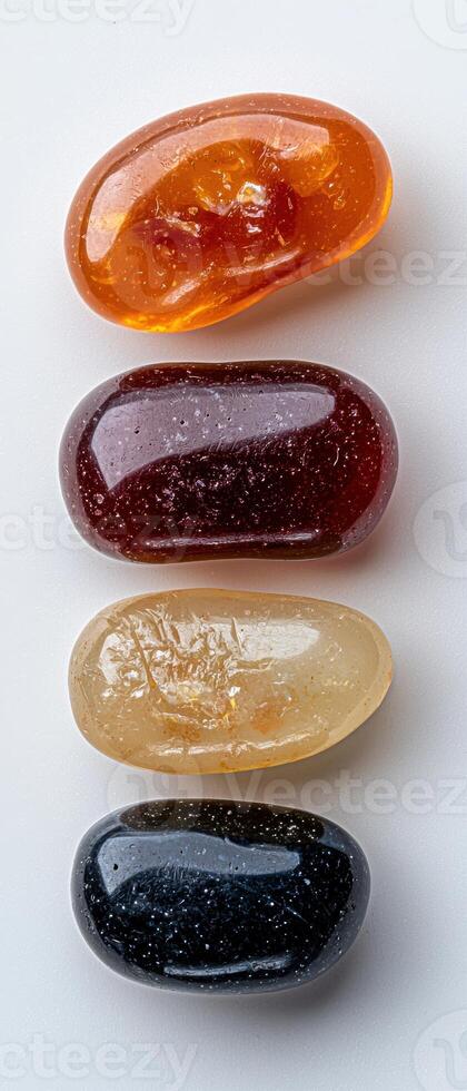 Four smooth, colorful stones arranged in a row on a white background photo