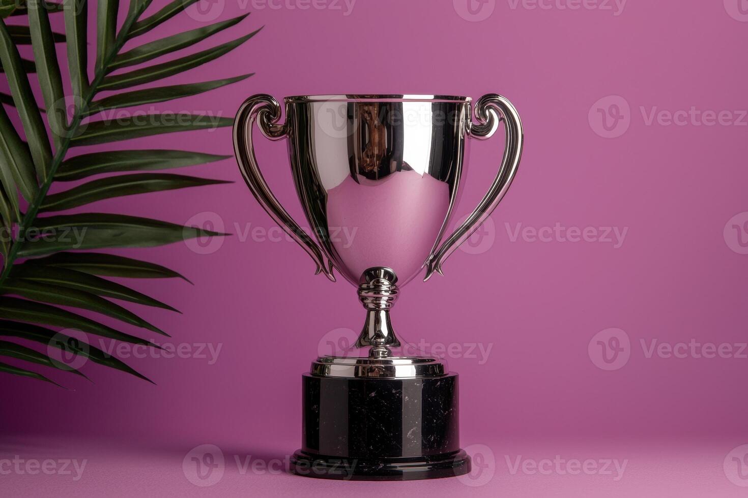 Silver trophy cup on purple background with palm leaf photo