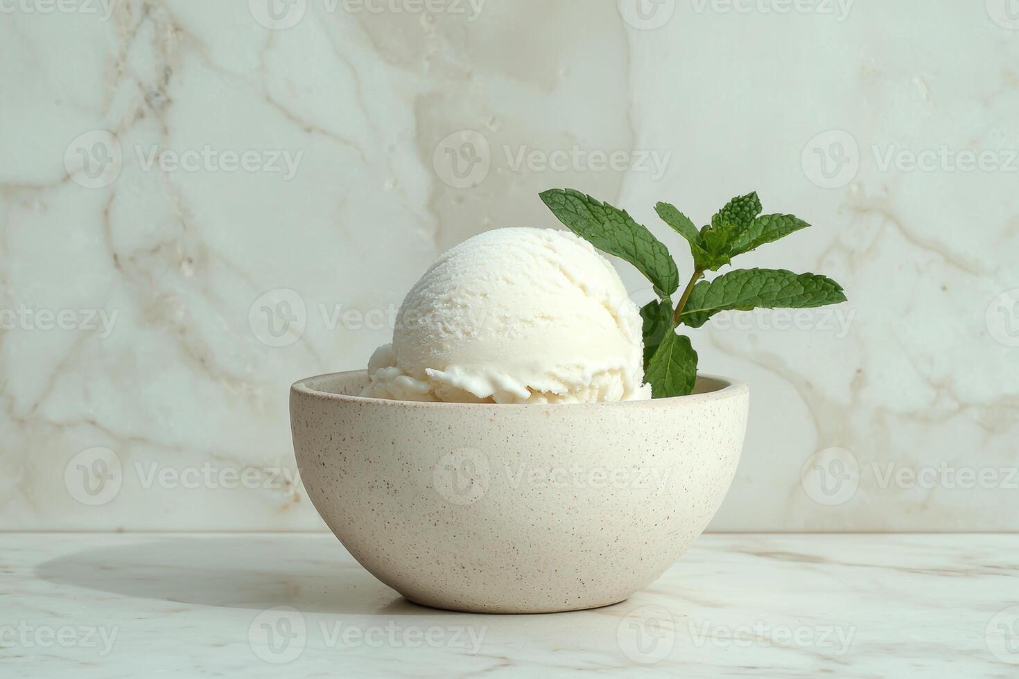 A scoop of vanilla ice cream in a small bowl with a sprig of mint photo