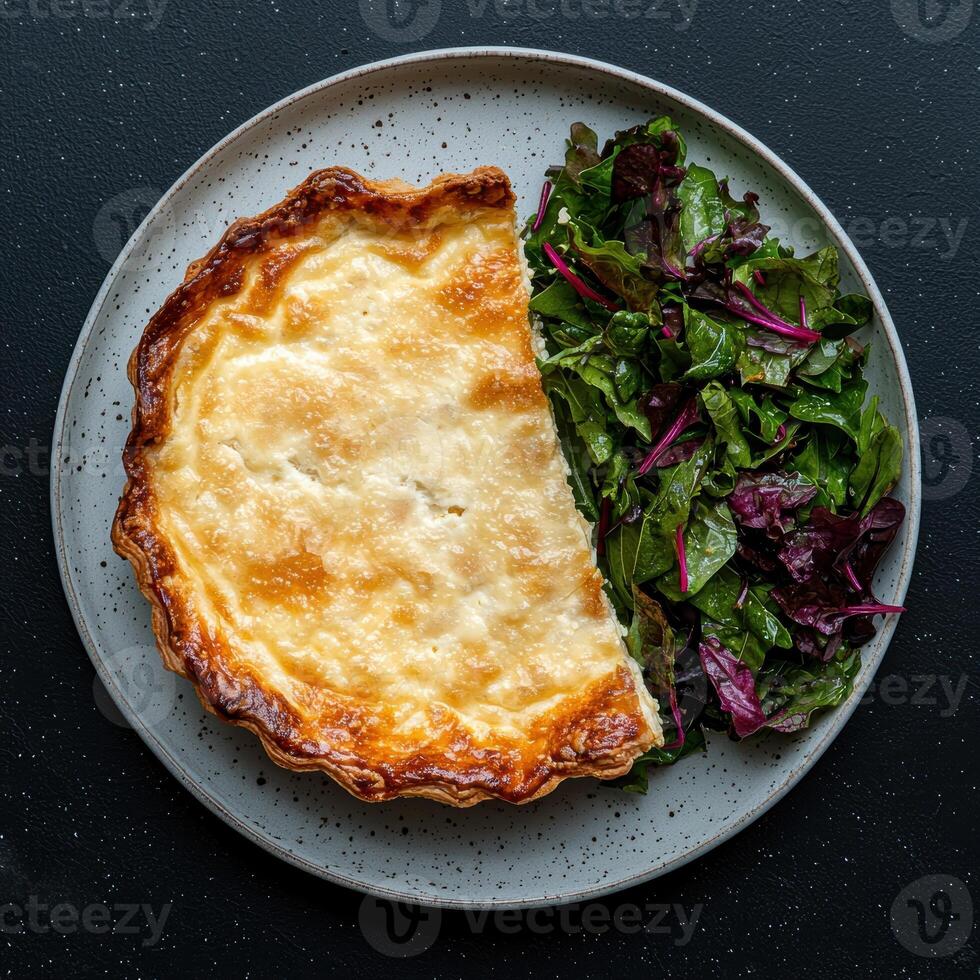 A slice of quiche with a side salad on a gray plate photo