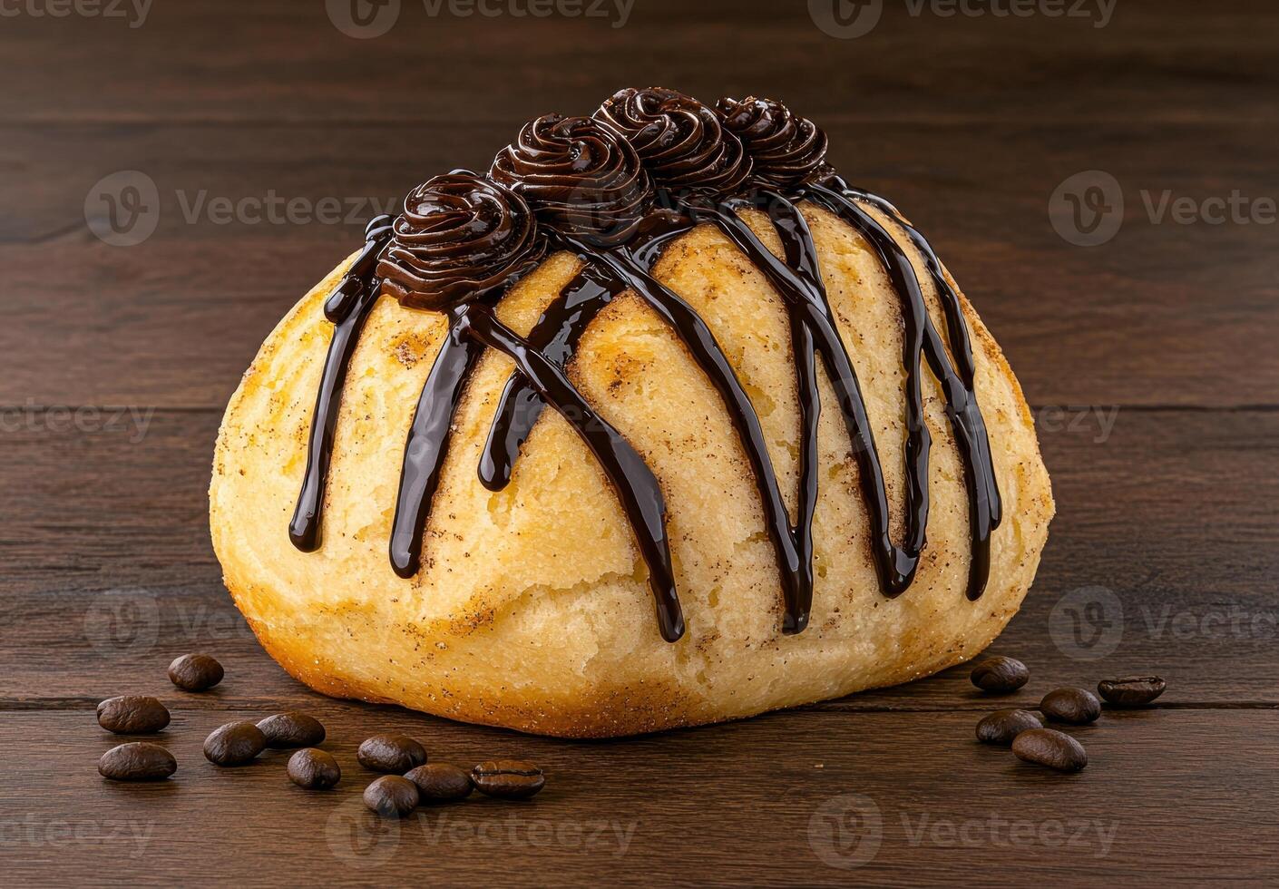 Close up of a delicious chocolate covered pastry with coffee beans scattered on a wooden surface photo