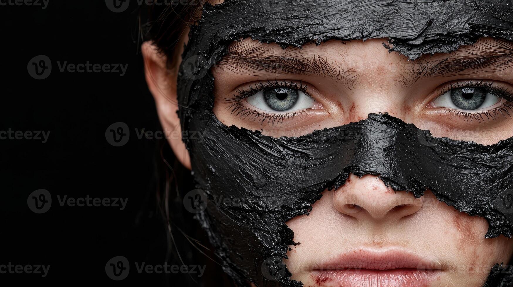 Close up of a womans face with a black mud mask photo