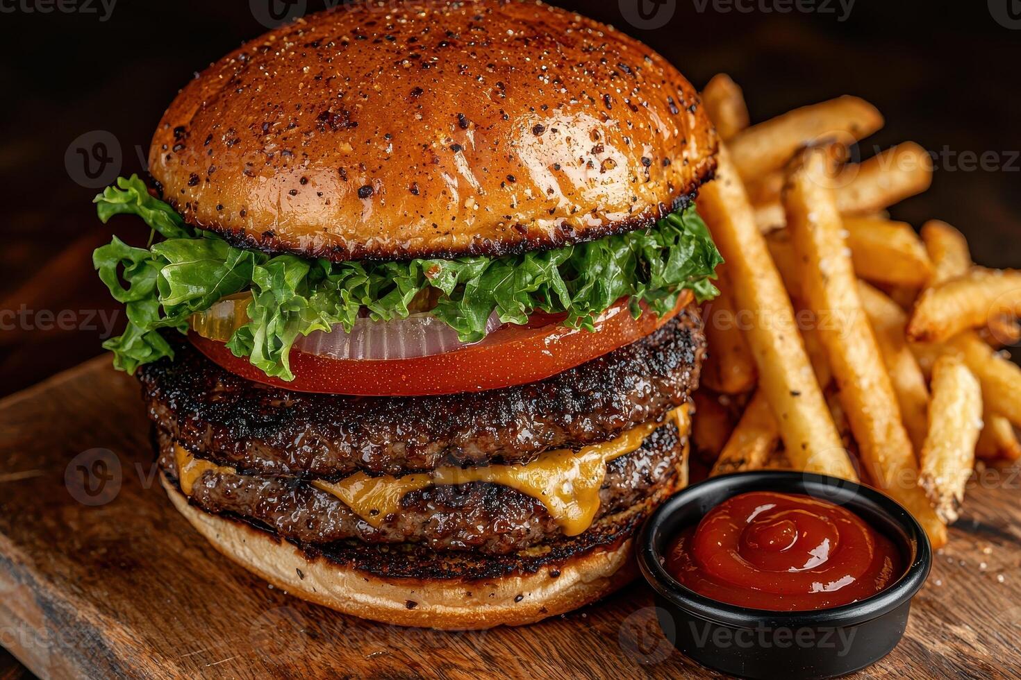 a hamburger with cheese, lettuce and tomato on a wooden cutting board photo