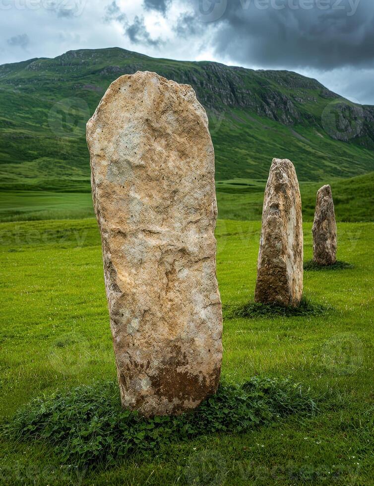 Ancient standing stones in a green field under a dramatic sky photo