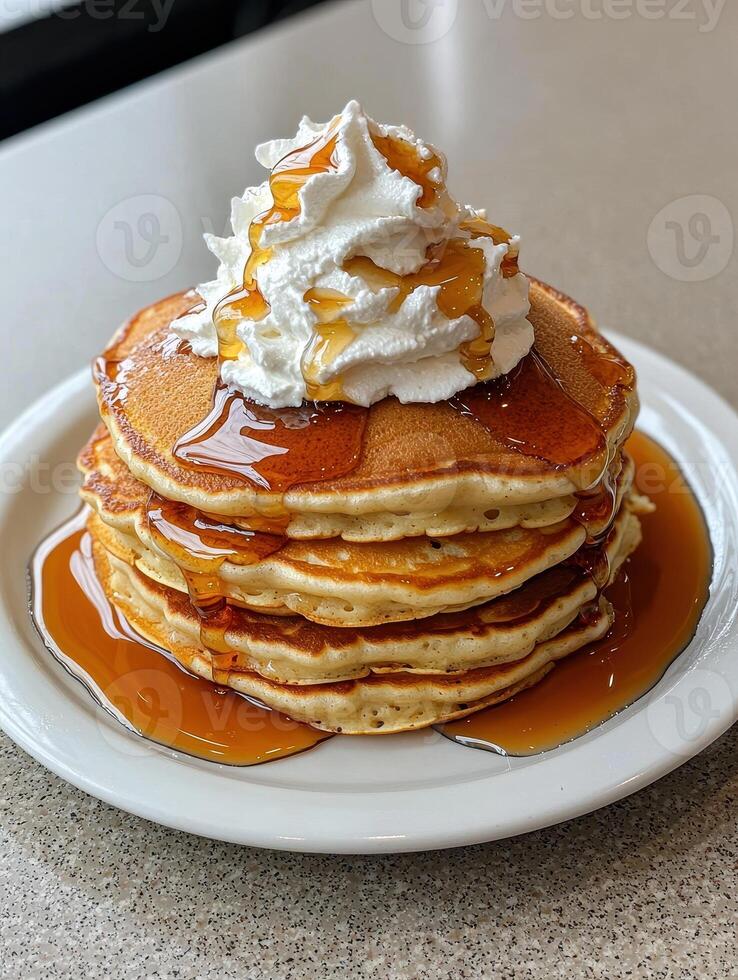 a stack of pancakes with whipped cream and syrup photo