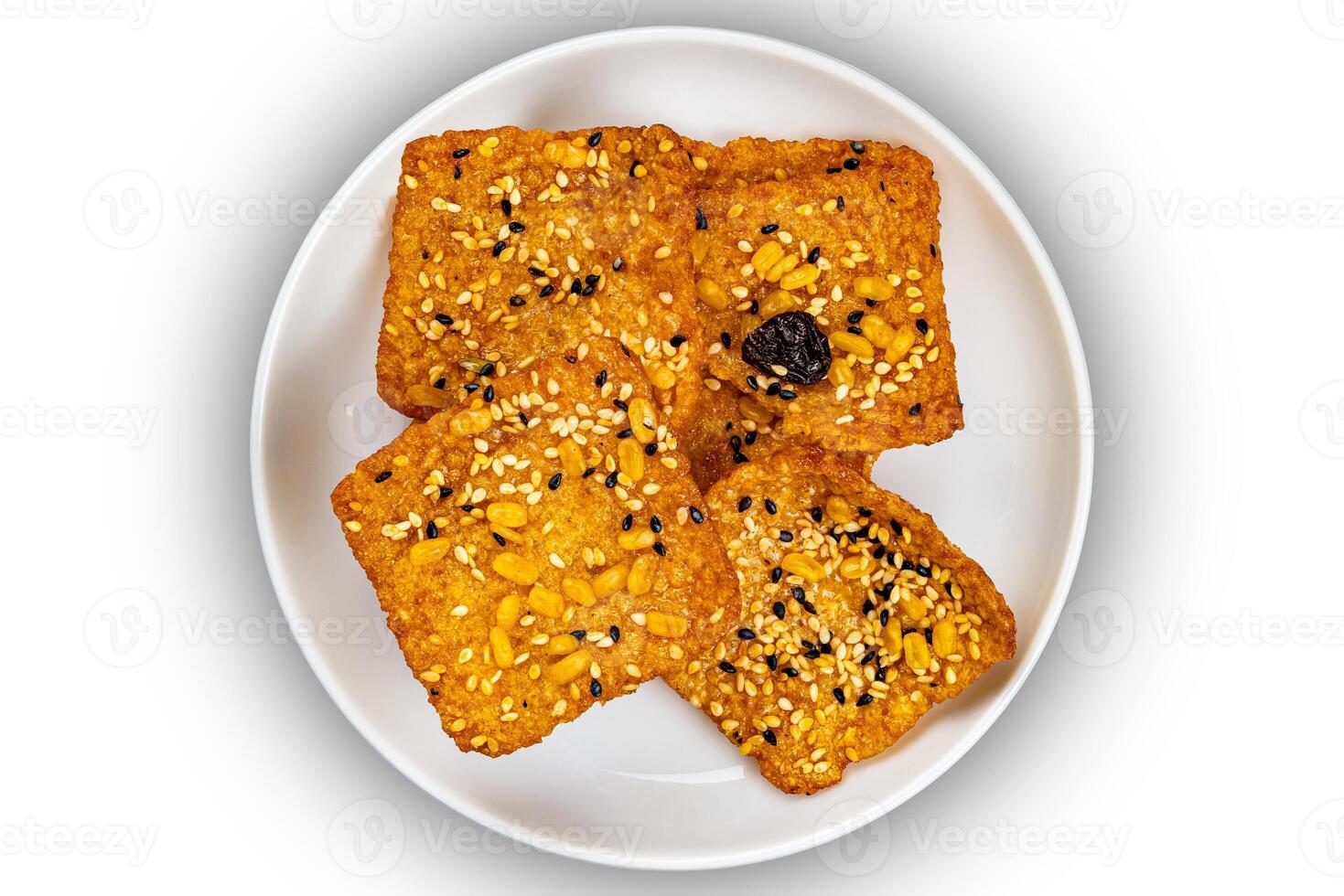 Top view of square shape bars of crispy homemade multigrain rice cracker in white ceramic dish. photo